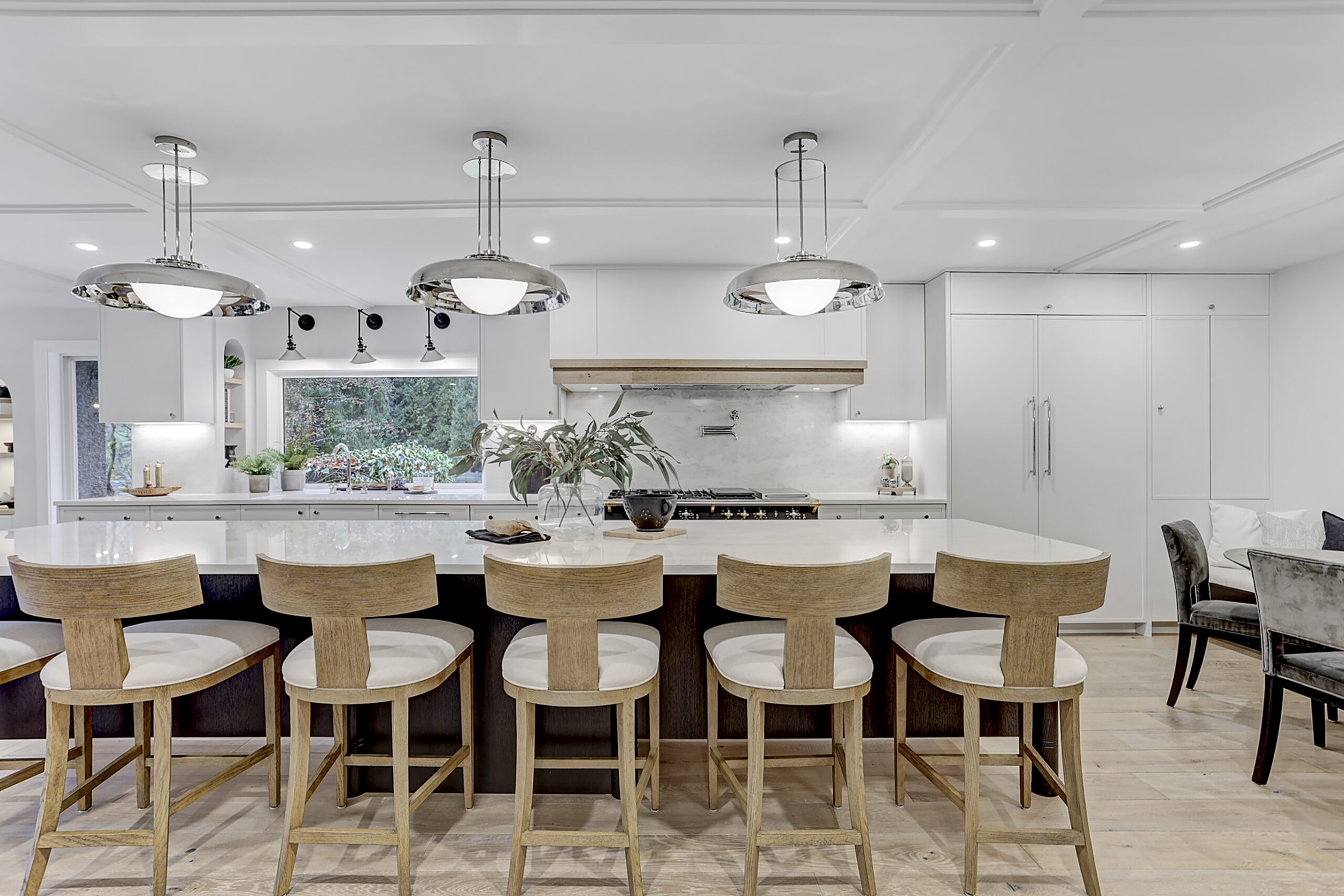 Traditional kitchen renovation showcasing custom cabinetry, a central island, stone countertops, and classic detailing throughout.